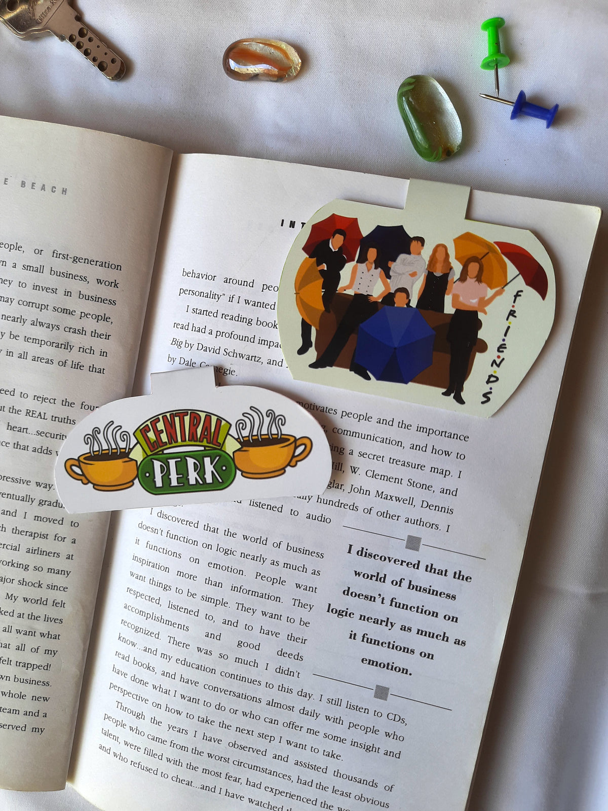 Open book with a 'Central Perk' bookmark featuring characters from Friends.