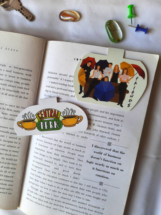 Open book with a 'Central Perk' bookmark featuring characters from Friends.